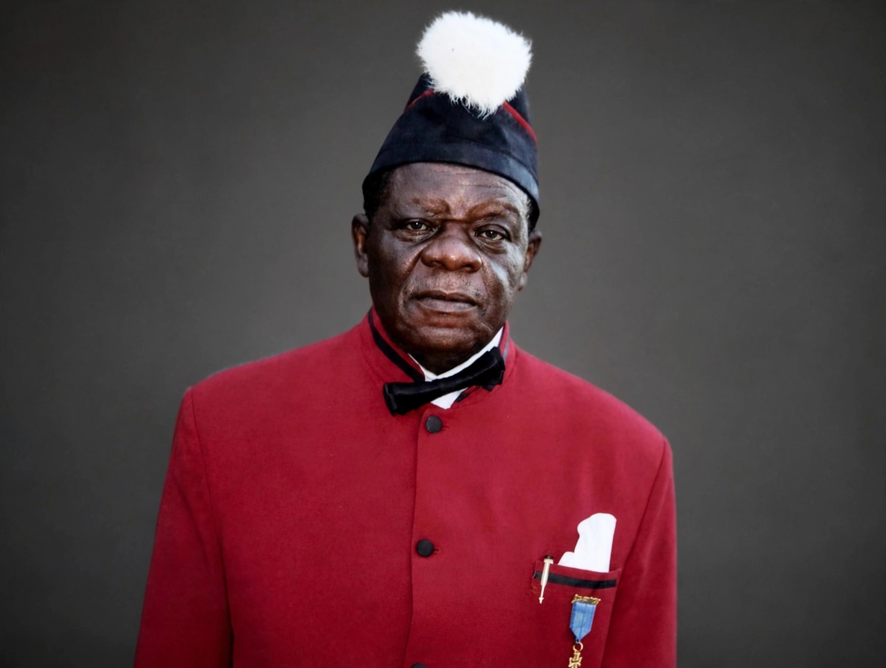 Portrait of Hans Suku-Ogbari Ogbari XII in younger days wearing red and yellow patterned traditional shirt, A knight of Anglican 