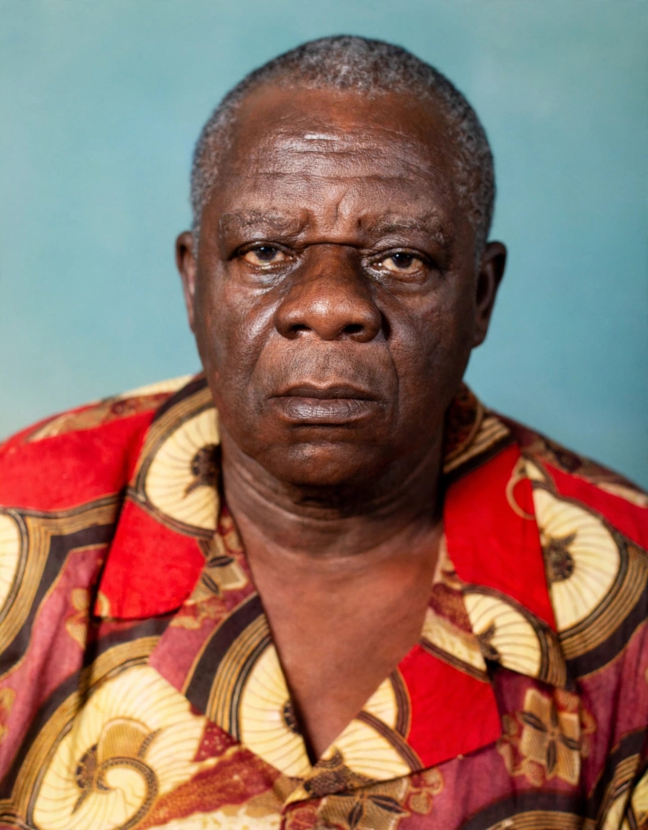 Portrait of Hans Suku-Ogbari Ogbari XII in younger days wearing red and yellow patterned traditional shirt, Nembe Kingdom Bayelsa